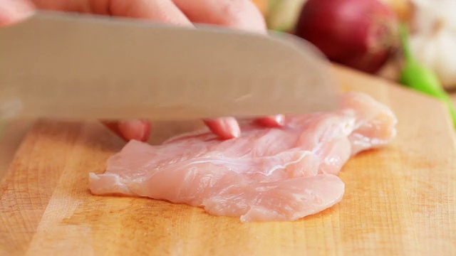 厨师用三德厨刀将鸡胸肉切成薄片