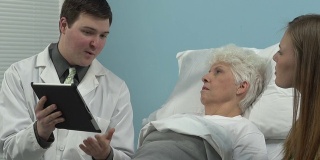 医生用平板电脑与老年病人交谈
