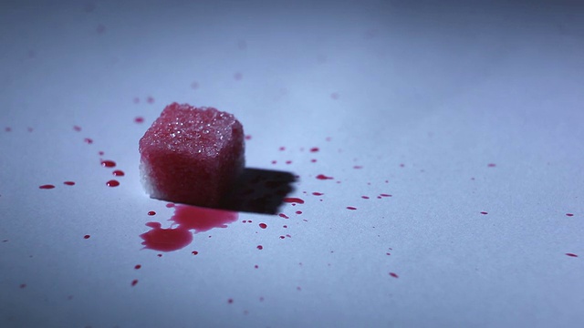 红色液体滴在一块糖上