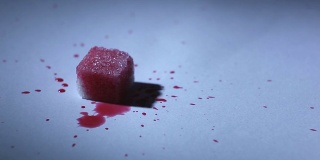 红色液体滴在一块糖上