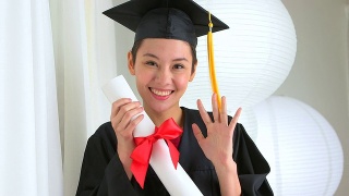 亚洲毕业生挥舞着文凭视频素材模板下载