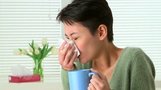 中国妇女因感冒打喷嚏和喝茶而生病视频素材模板下载