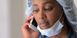 一位黑人妇女在给病人的家人打电话