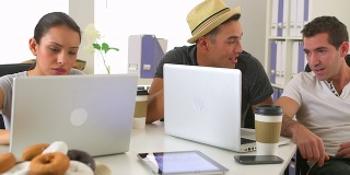 西班牙裔和白人同事一起在笔记本电脑上工作