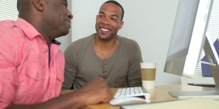 两个快乐的黑人商人正在看电脑上的数据