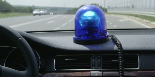 在高速公路上驾驶带蓝色闪光灯的汽车