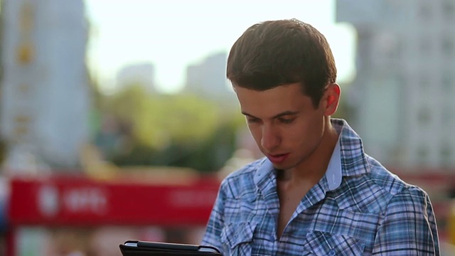 微笑的男人阅读平板电脑pad，转身微笑，城市