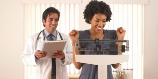 非洲裔美国妇女与医生检查体重