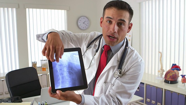 西班牙裔医生用平板电脑显示颈部x光片