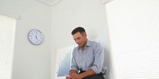 Latino business man texting in office
