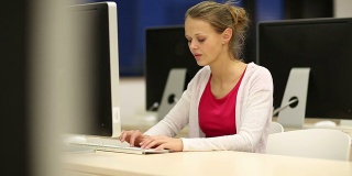 在计算机教室工作的年轻女学生
