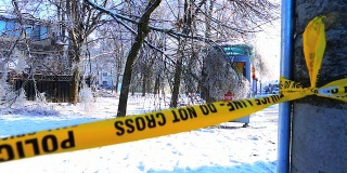 在冬季冰暴中，警察在倒下的树前设置了警戒线