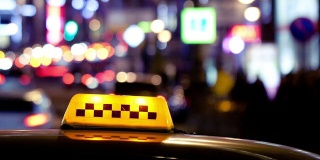 出租车标志后的城市交通在夜间的时间