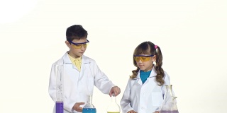 两个可爱的孩子戴着防护眼镜，穿着制服，在白色背景上做化学实验