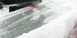 男人清理车上的雪