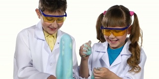 两个可爱的化学家孩子做有趣和成功的实验与蓝色泡沫，玩，孤立在白色背景，慢动作，近距离