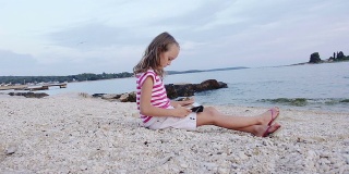 慢动作:沙滩上用触控板的小女孩