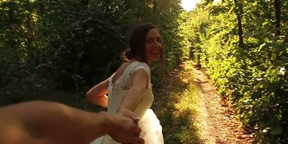 浪漫婚礼概念:新娘牵手森林漫步