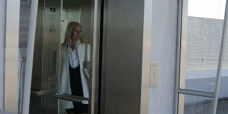 金发女人在电梯前等着