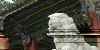 大理石狮子雕像前的一个古老的佛教木制寺庙-高清录像