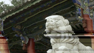 大理石狮子雕像前的一个古老的佛教木制寺庙-高清录像视频素材模板下载