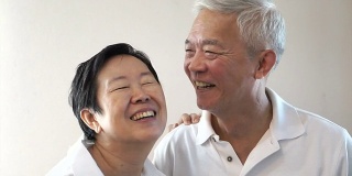 Happy Asian senior couple on white background. Laughing and talking