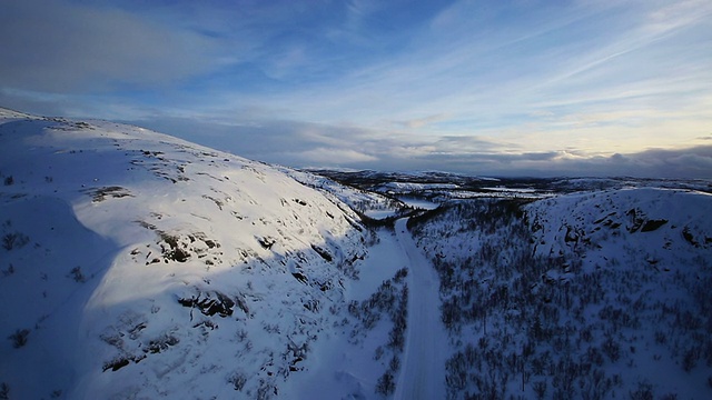 冬季驾驶-冬季道路的乡村道路，通过一个冬季的山区景观