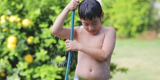 快乐的亚洲儿童玩溅橡胶管