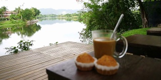 热咖啡和香蕉纸杯蛋糕，河背景