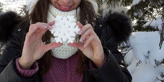 年轻女子手持装饰性雪花