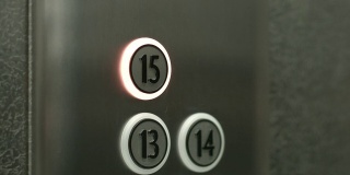 一个男人在电梯里按下了15楼的按钮