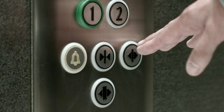 一名男子按下按钮打开电梯门