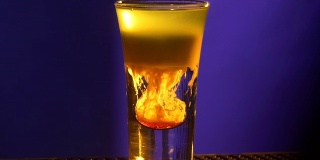 调酒师的双手继续制作鸡尾酒，将红色糖浆加入蓝色，小杯，慢动作