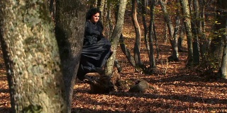 在秋天的森林里奔跑的黑衣女人