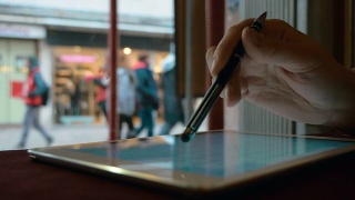 一个在咖啡馆靠窗边用触控板工作的女人视频素材模板下载
