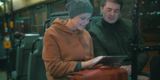 年轻人在公交车上使用平板电脑