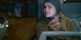 一名年轻女子在公交车上发短信