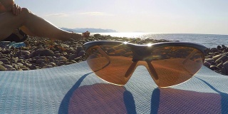 偏光运动自行车太阳镜在野生海滩在夏天