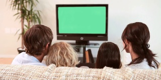 一家人坐在一起看电视