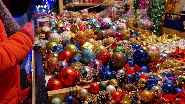 一张满是圣诞装饰品的桌子和人们想买一些圣诞树球的画面
