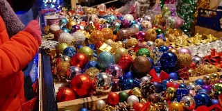 一张满是圣诞装饰品的桌子和人们想买一些圣诞树球的画面