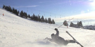 慢动作:滑雪者在滑雪道上摔倒