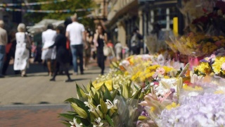 鲜花和市中心购物者。视频素材模板下载