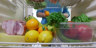 家庭主妇从冰箱里拿出蔬菜