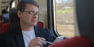 一个拿着手机的男人从火车窗口欣赏风景