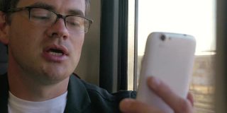 一名男子在火车上用手机视频聊天