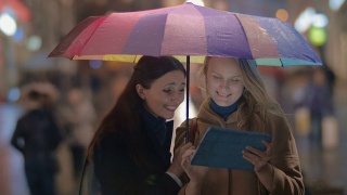 女性朋友在城市的雨天晚上使用触控板视频素材模板下载