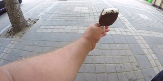 在炎炎夏日的城市里，男人吃着棒棒巧克力冰淇淋