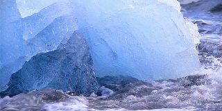 冰岛Jokulsarlon，深蓝色的冰川冰，海浪拍打着海岸