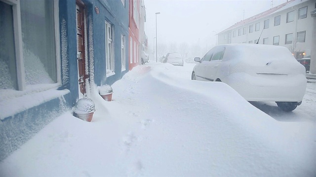 厚厚的积雪堵塞了居民区的人行道和汽车